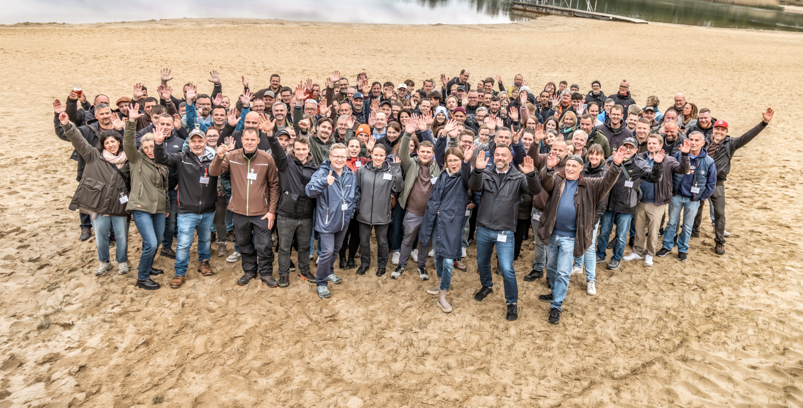 Gruppenbild von 150 Menschen am Strand - BALANCE Mitarbeitende